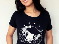 A girl smiling wearing a Lolligag Day of the Dead shirt