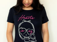 A girl staring at the graphic of the Dancing Hearts Lolligag Tee