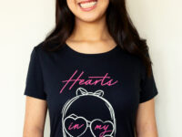 A girl laughing wearing the Dancing Hearts Lolligag Tee