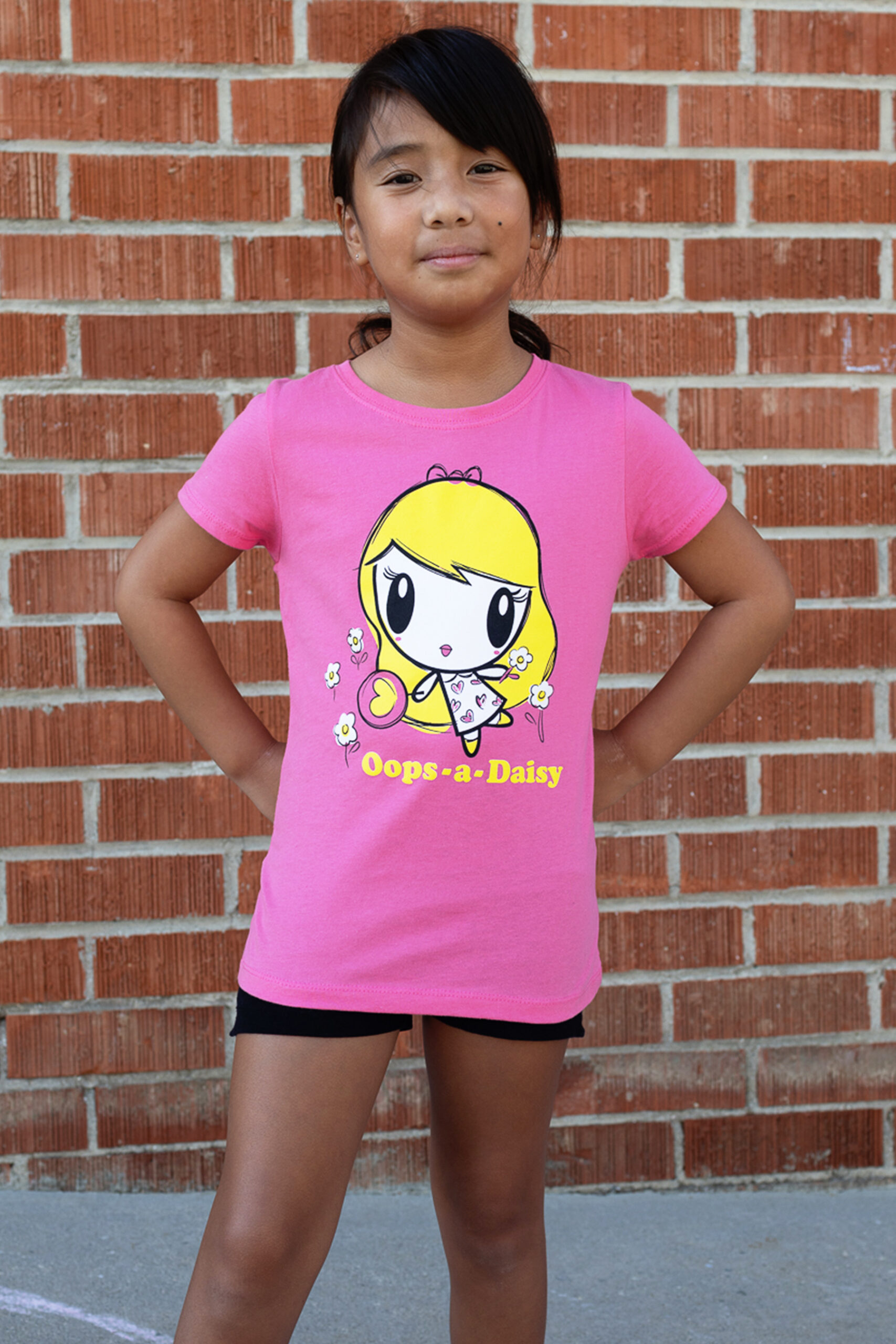 Girl with hands on her hips wearing the Oops A Daisy Lolligag T-shirt